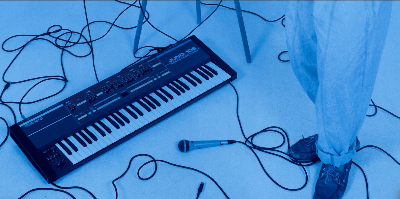 Blue Clocks Green, aka Lange with Roland Juno 106 Keyboard on floor with Mic and cables.
